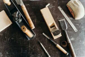 Why don't my kitchen cabinets fit? - Congratulations.. You've encountered the 'ghost measurement!' A collection of woodworking tools on a workshop table, showcasing craftsmanship essentials.
